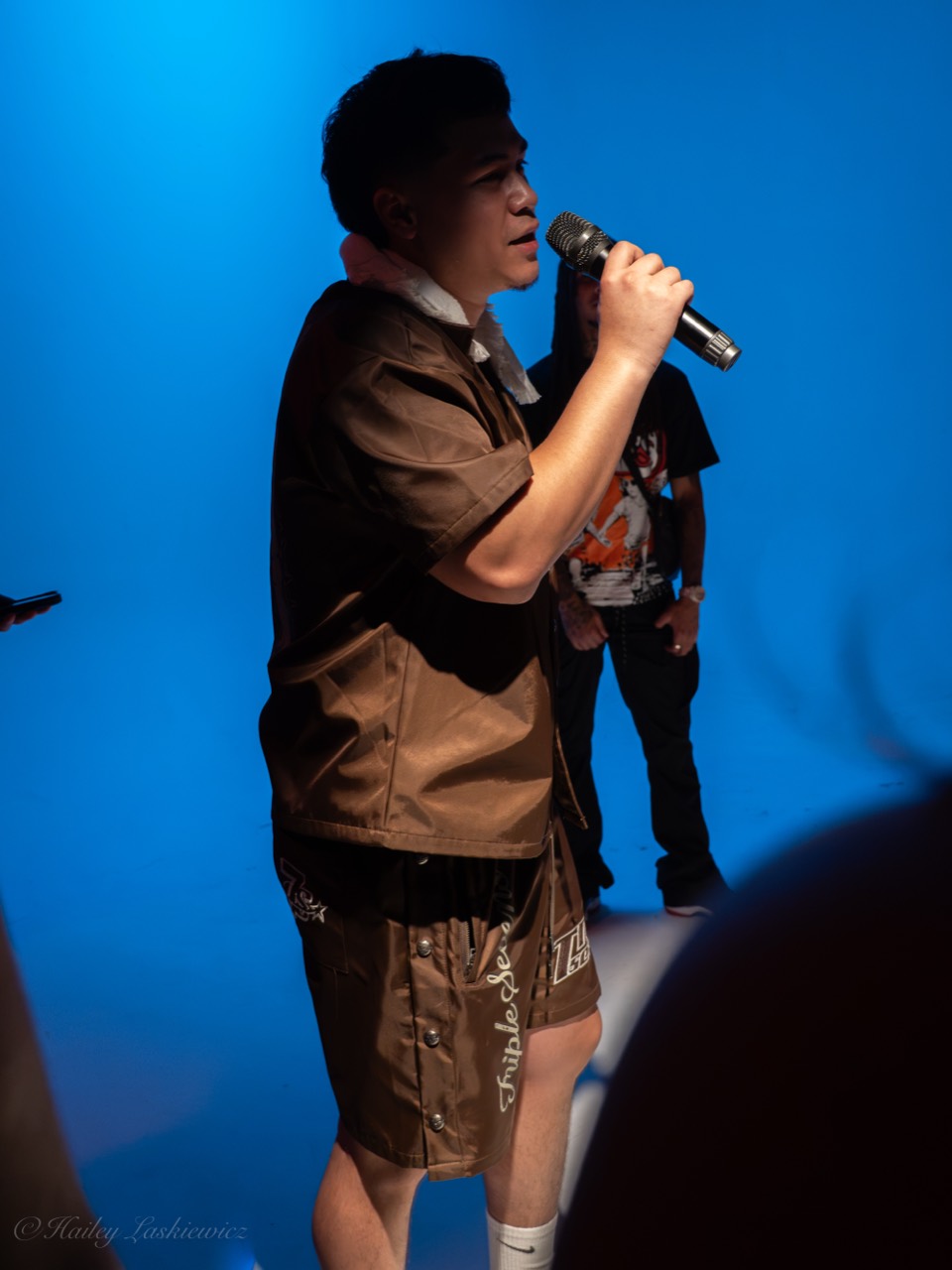 Project X speaking into a microphone at a live event